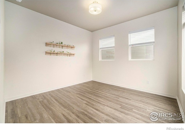 unfurnished room with hardwood / wood-style flooring