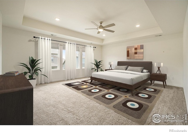 bedroom featuring ceiling fan, carpet flooring, and a tray ceiling