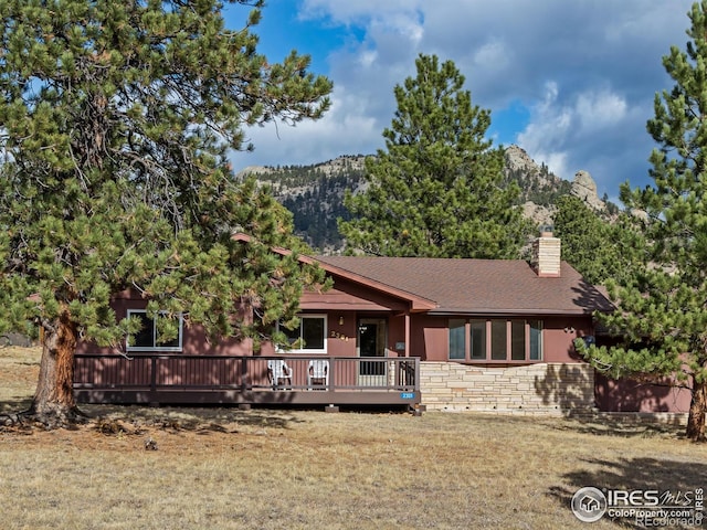 view of front facade with a front yard and a deck with mountain view