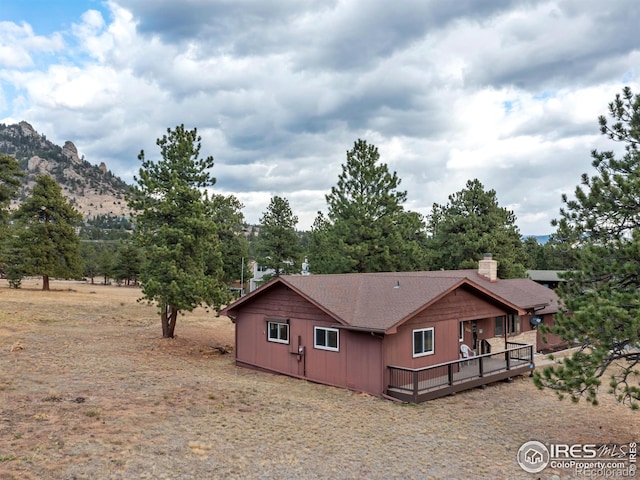 back of property with a deck with mountain view