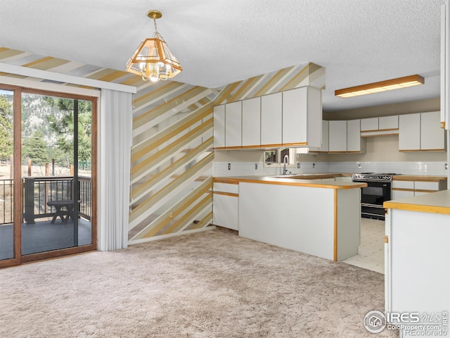 kitchen with light carpet, sink, decorative light fixtures, range, and white cabinets