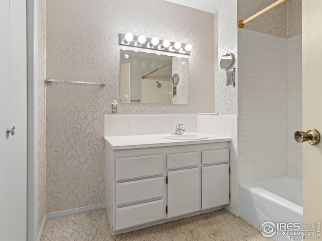 bathroom featuring tiled shower / bath and vanity