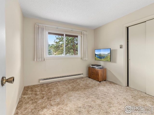 bedroom featuring a baseboard radiator, light carpet, a textured ceiling, and a closet