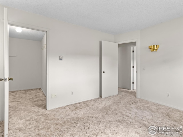 unfurnished bedroom with light carpet and a textured ceiling