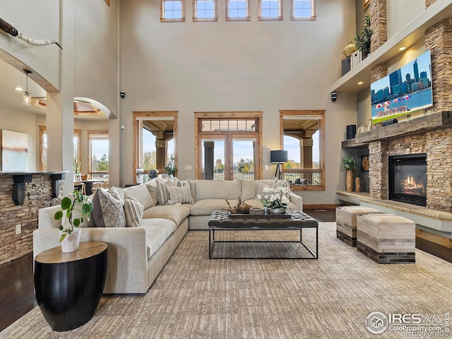 living room with a wealth of natural light, a high ceiling, and hardwood / wood-style flooring