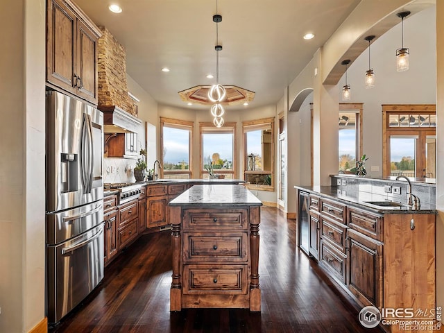 kitchen featuring stainless steel appliances, plenty of natural light, dark hardwood / wood-style floors, and hanging light fixtures