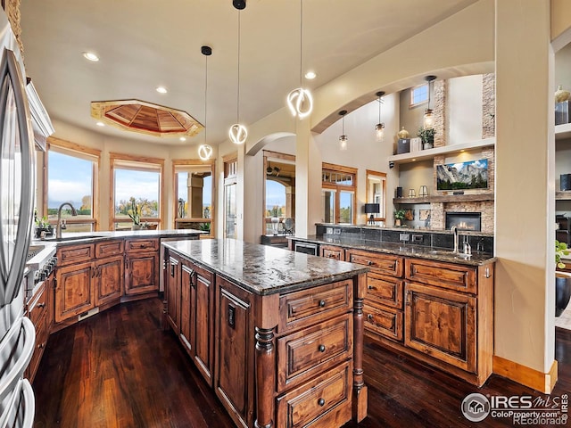 kitchen featuring sink, hanging light fixtures, dark hardwood / wood-style floors, and kitchen peninsula