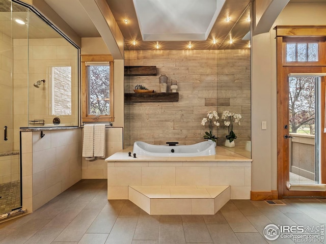 bathroom featuring a raised ceiling, tile patterned flooring, and plus walk in shower