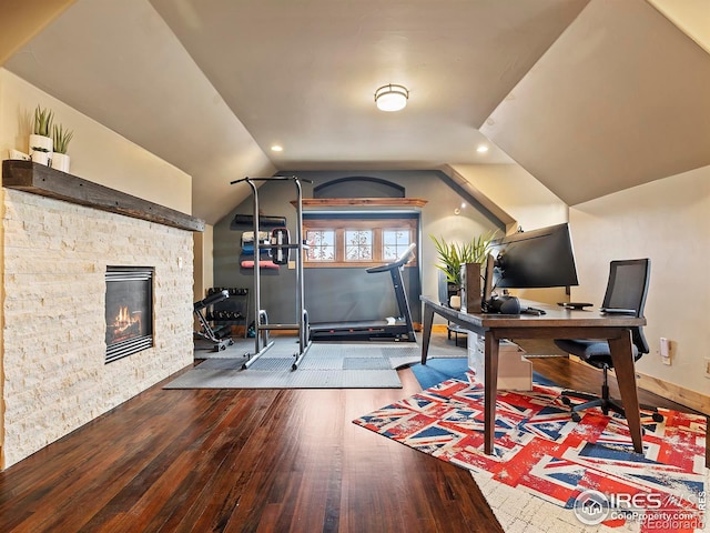 home office with hardwood / wood-style flooring, a fireplace, and vaulted ceiling