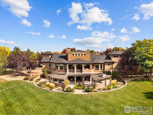 rear view of house with a patio, a pergola, and a lawn