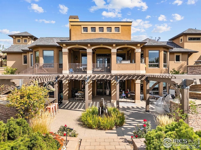 rear view of property featuring a patio area, a balcony, and a pergola