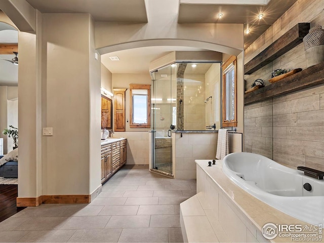 bathroom with vanity, ceiling fan, plus walk in shower, and tile patterned flooring