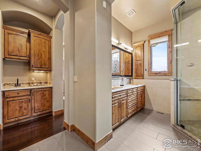 bathroom featuring walk in shower, vanity, and tile patterned floors