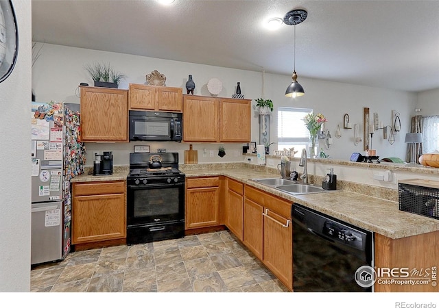 kitchen with kitchen peninsula, black appliances, sink, and pendant lighting