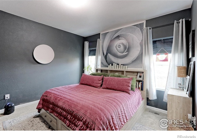 bedroom featuring multiple windows and light colored carpet