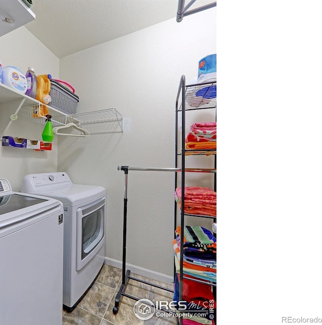 laundry room with light tile patterned floors, washing machine and dryer, and a textured ceiling