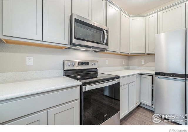 kitchen featuring white cabinetry, light hardwood / wood-style flooring, and stainless steel appliances