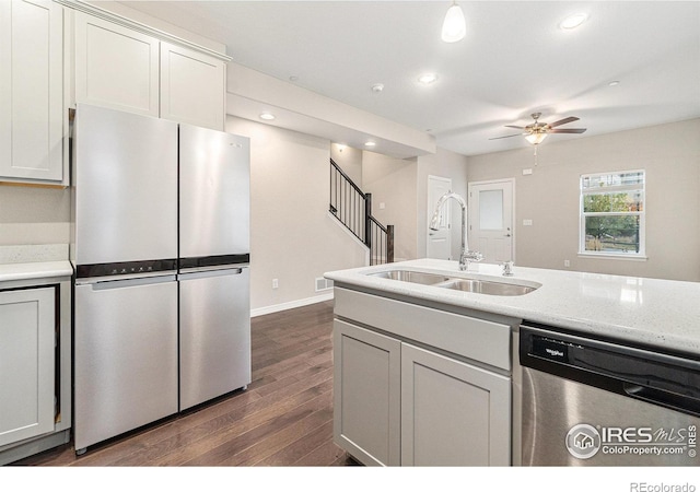 kitchen with sink, ceiling fan, appliances with stainless steel finishes, white cabinets, and dark hardwood / wood-style flooring