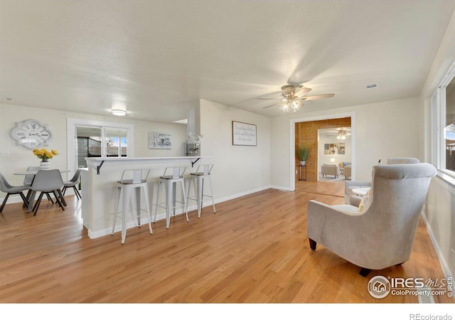 interior space with ceiling fan, a textured ceiling, and light hardwood / wood-style flooring