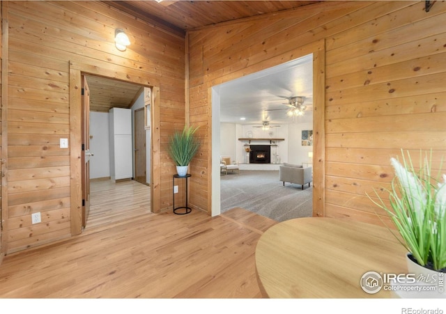 hallway featuring wood walls, hardwood / wood-style floors, and wooden ceiling