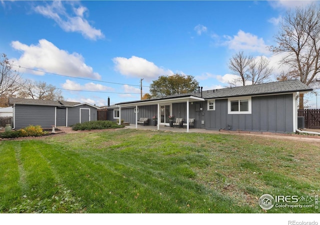 back of property with a patio area and a yard