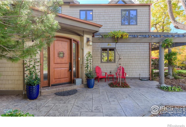 entrance to property featuring a patio area and a pergola