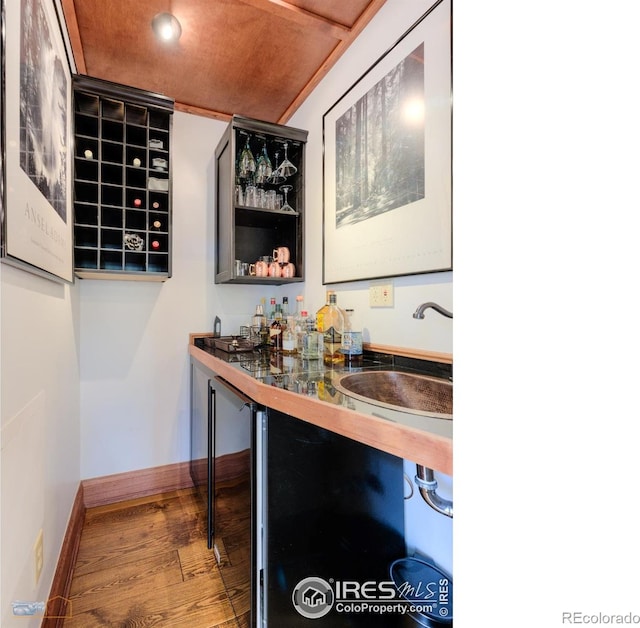 bar with hardwood / wood-style floors, sink, beverage cooler, and wooden ceiling