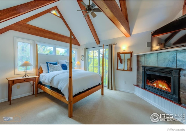 bedroom with ceiling fan, light carpet, beamed ceiling, and a fireplace