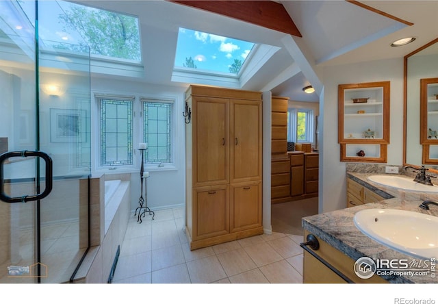 bathroom featuring vanity, lofted ceiling with skylight, a healthy amount of sunlight, and tile patterned floors