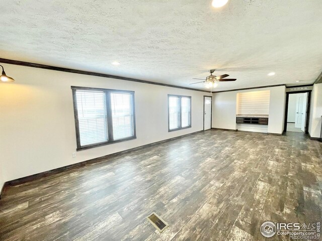 unfurnished living room with ceiling fan, crown molding, a textured ceiling, and dark hardwood / wood-style flooring