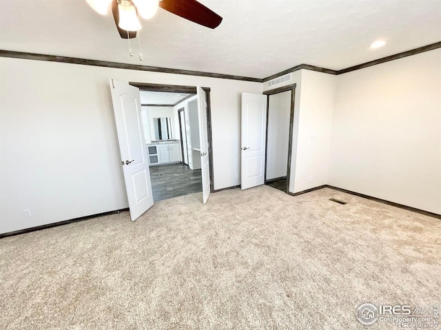 unfurnished bedroom featuring crown molding, light colored carpet, and ceiling fan