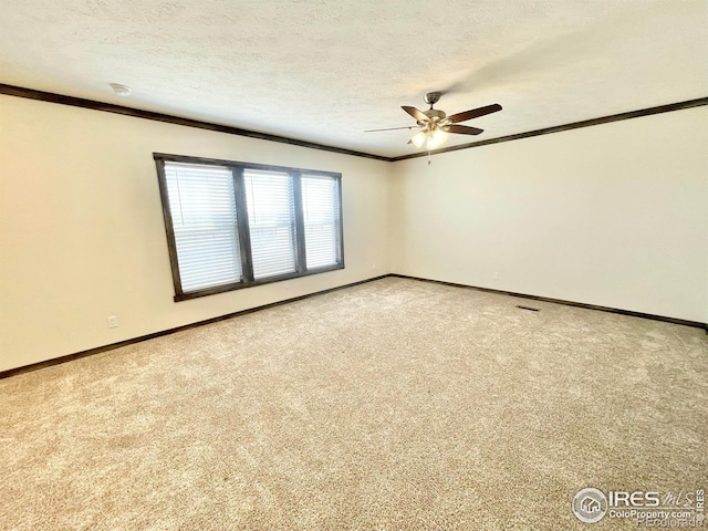 spare room featuring crown molding, carpet floors, a textured ceiling, and ceiling fan