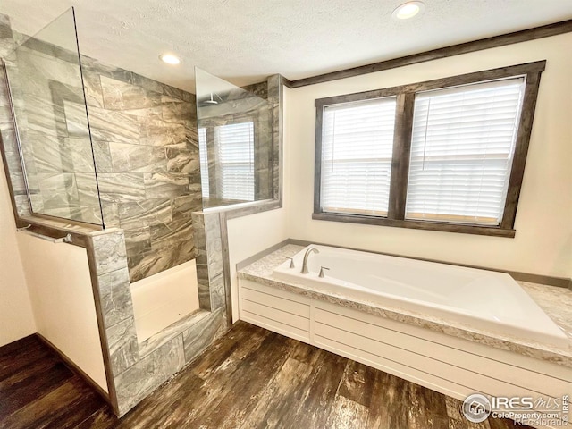 bathroom with hardwood / wood-style floors, crown molding, plus walk in shower, and a textured ceiling