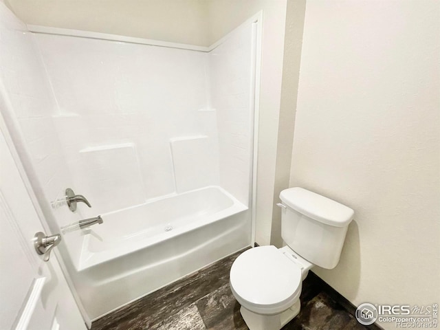 bathroom featuring toilet, hardwood / wood-style floors, and tub / shower combination