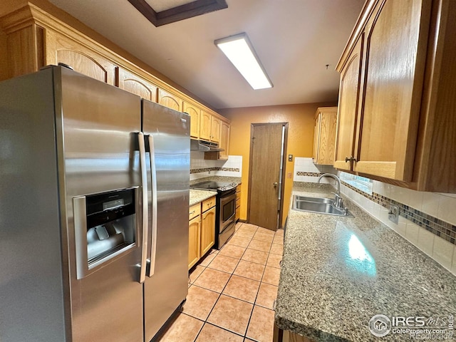 kitchen featuring light tile patterned flooring, stone counters, stainless steel appliances, and sink