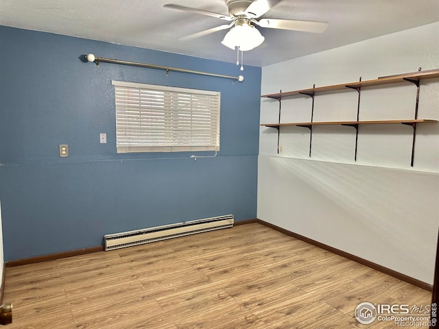 unfurnished room featuring a baseboard heating unit, light hardwood / wood-style flooring, and ceiling fan