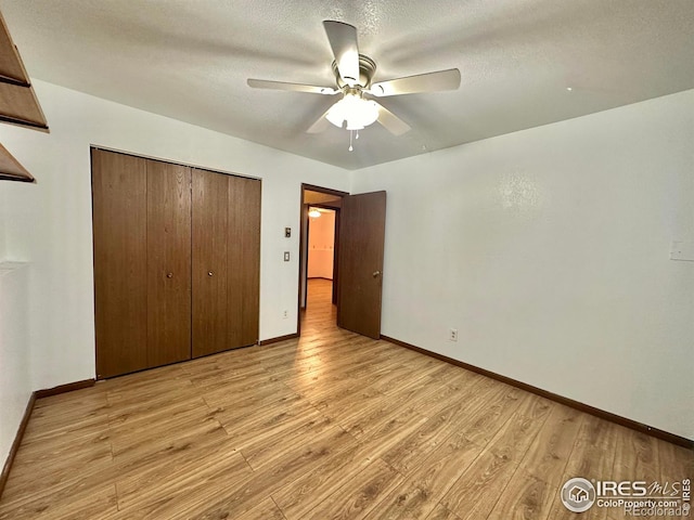 unfurnished bedroom with a closet, ceiling fan, a textured ceiling, and light hardwood / wood-style flooring