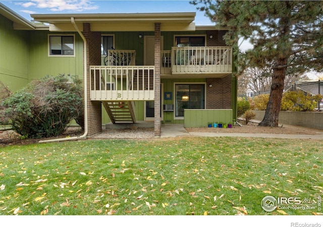 back of house featuring a balcony, a yard, and a patio