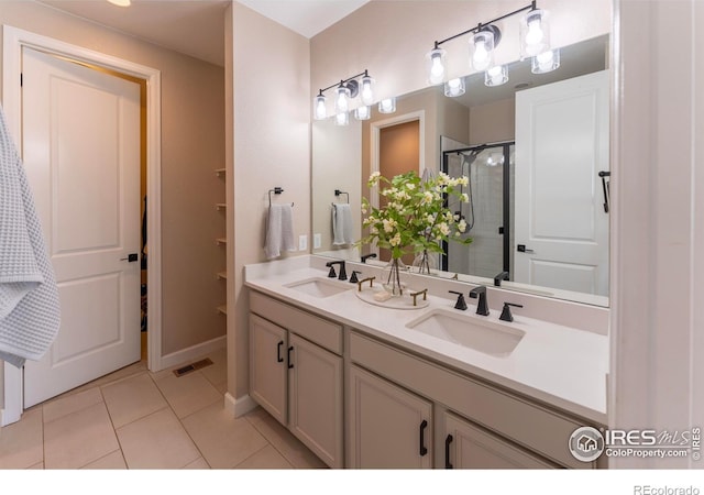 bathroom featuring vanity, an enclosed shower, and tile patterned floors