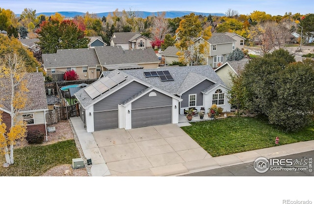 front of property with a mountain view, a front yard, and a garage