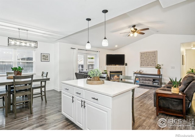 kitchen with white cabinetry, hanging light fixtures, lofted ceiling, and dark hardwood / wood-style flooring