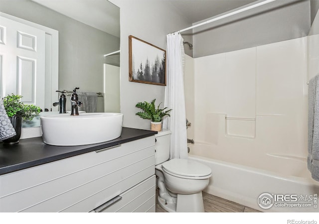 full bathroom with vanity, hardwood / wood-style floors, shower / bath combo, and toilet