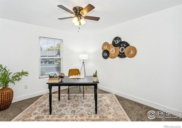 carpeted home office featuring ceiling fan