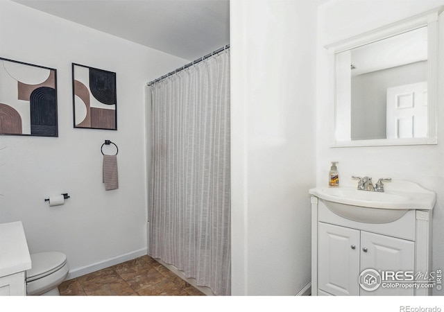 bathroom with vanity, toilet, and curtained shower