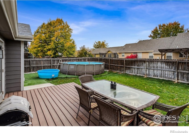 deck with a yard and a fenced in pool