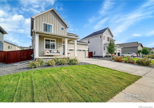 view of front of home featuring a front yard, a porch, and a garage