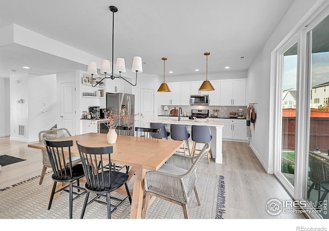 dining space featuring sink and light hardwood / wood-style floors