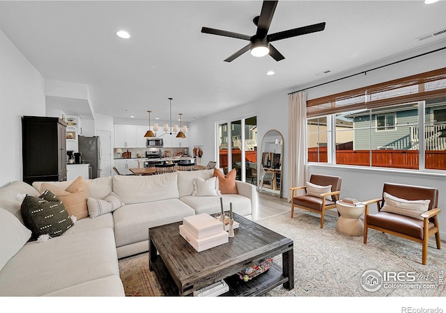 living room with ceiling fan and light wood-type flooring