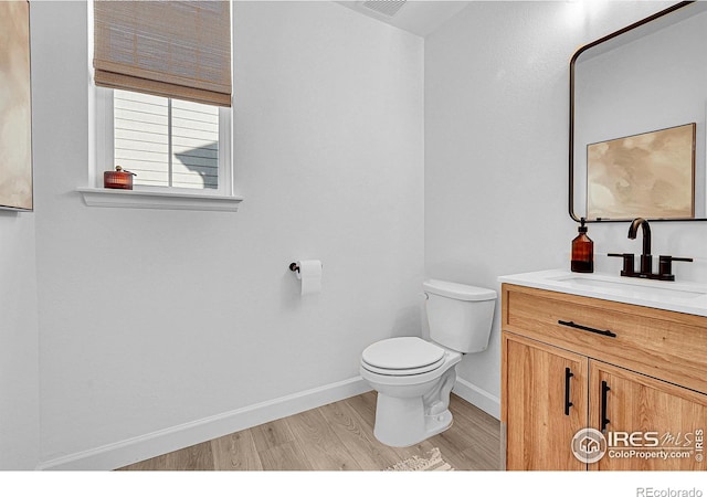 bathroom with hardwood / wood-style floors, vanity, and toilet