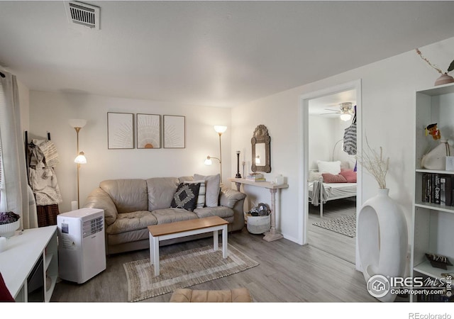 living room featuring wood-type flooring and ceiling fan